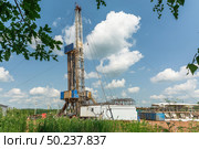 Drilling a well in an oil field. Mobile drilling rig and drilling equipment. Summer. Beautiful sky and nature. Стоковое фото, фотограф Владимир Ендовицкий / Фотобанк Лори