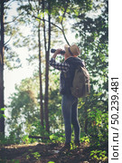 Woman with Binoculars walking in the forest . Стоковое фото, агентство Ingram Publishing / Фотобанк Лори