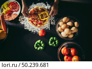 Top view of woman hand put topping on homemade pizza. Стоковое фото, агентство Ingram Publishing / Фотобанк Лори
