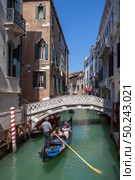 Picturesque view of Gondola on lateral narrow Canal, Venice, Italy. Classical picture of venetian canals with gondola across canal.. Venice canal scene in Italy. Стоковое фото, агентство Ingram Publishing / Фотобанк Лори