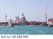 Beautiful view of traditional Gondola on famous Canal Grande with Basilica di Santa Maria della Salute in beautiful light at sunset in Venice, Italy.. Grand Canal in Venice. Стоковое фото, агентство Ingram Publishing / Фотобанк Лори