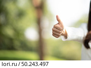 successful girl pointing thumb up; portrait of cheerful smiling woman pointing up approving, yes, ok, good. Стоковое фото, агентство Ingram Publishing / Фотобанк Лори