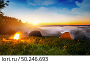 Tents and bonfire in steppe near river at sunrise. Стоковое фото, агентство Ingram Publishing / Фотобанк Лори