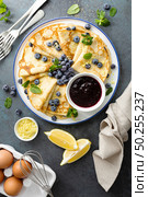 Crepes, thin pancakes with blueberry jam and fresh berries with lemon zest. Стоковое фото, агентство Ingram Publishing / Фотобанк Лори