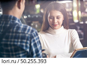 Asian woman customer using mobile phone scane QR code on credit card reader EDC machine to pay a waiter for coffee purchase at table in cafe. Стоковое фото, агентство Ingram Publishing / Фотобанк Лори