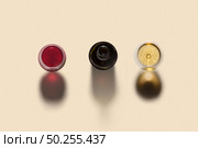 Top view on alcohol drink set with two glasses of red and white wine and opened bottle with dark shadows on a light beige background, copy space.. Drink set from bottle and two wine glasses with shadows. Стоковое фото, агентство Ingram Publishing / Фотобанк Лори