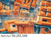 Aerial view of houses with orange roofs at sunset in summer in Dubrovnik, Croatia. Top view of beautiful architecture in old city. Historical centre, buildings, walking people on the street. Travel. Стоковое фото, агентство Ingram Publishing / Фотобанк Лори