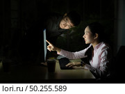 Young adult asian businessman dicuss with collegue about work late at night in their office with desktop computer. Using as hard working and working late concept. Стоковое фото, агентство Ingram Publishing / Фотобанк Лори