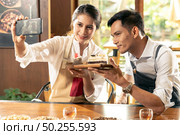 Selfie shit of two BLOGGER of young adult asian owner entrepreneur review cafe coffee shop for social media and online marketing in cafe. Using for startup of small business maketing and consumerism concept. . Стоковое фото, агентство Ingram Publishing / Фотобанк Лори