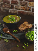 Green pea soup with linseed and pumpkin and sunflower seeds on a rustic kitchen countertop. Стоковое фото, агентство Ingram Publishing / Фотобанк Лори