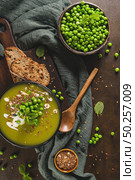 Green pea soup with linseed and pumpkin and sunflower seeds on a rustic kitchen countertop. Стоковое фото, агентство Ingram Publishing / Фотобанк Лори