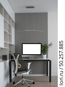 Modern mockup computer monitor on an office table and orthopaedic chair as a well-disigned comfortable working place with natural daylighting, copy space. Home office concept.. Home working place with modern desk and mock-up computer monitor. Стоковое фото, агентство Ingram Publishing / Фотобанк Лори