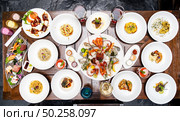Table top view premium variety of international food in restaurant of lobster shrimp steak beef lamb pasta spaghetti risotto rice sushi sashimi and wine using for buffet food drink background. Стоковое фото, агентство Ingram Publishing / Фотобанк Лори