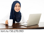 Asian young adult woman wearing hijab Working from home using laptop search and doing office work isolated in white background - office, business, finance and work station concept. Стоковое фото, агентство Ingram Publishing / Фотобанк Лори