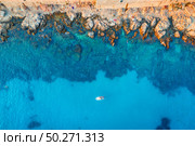 Aerial view of beach with stones and rocks, alone boat in adriatic sea at sunset in summer. Top view of yacht in transparent blue water. Travel in Croatia. Nature background. Landscape with ocean. Стоковое фото, агентство Ingram Publishing / Фотобанк Лори