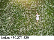 Beautiful girl lies in camomile daisy flower. View from above. Aerial photography. Стоковое фото, агентство Ingram Publishing / Фотобанк Лори