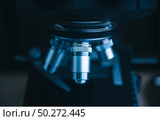 Focus on microscope with metal lens for experiments, educational demonstrations in clinical laboratories. Medicine researching concept. Blurred background. Стоковое фото, агентство Ingram Publishing / Фотобанк Лори