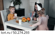 Children Drinking Juice on a Birthday Party at Home. Siblings, girls and a boy together celebrating a party, eating cake sitting at festive table. Little Kid Celebration. Surprise. Low key. Стоковое видео, видеограф Марина Демидюк / Фотобанк Лори