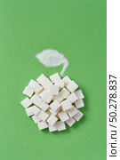 Creative composition from apple fruit handmade from different types of sweet sugar pressed cubes and leaf from granulated sugar on a light green background, copy space. Flat lay.. Handmade apple from sugar cubes and leaf on a green background. Стоковое фото, агентство Ingram Publishing / Фотобанк Лори