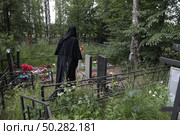Монахиня на могиле предков. Редакционное фото, фотограф Дмитрий Неумоин / Фотобанк Лори