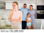 Upset teenage girl listening to disgruntled parents reprimanding her. Стоковое фото, фотограф Яков Филимонов / Фотобанк Лори