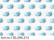 Creative pattern from medical antibacterial protective blue face masks on a white background. Flat lay Concept of prevention from respiratory sickness and viruses.. Health care pattern from medical masks on a white background. Стоковое фото, агентство Ingram Publishing / Фотобанк Лори