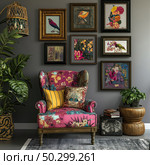Modern living room interior with a brightly decorated boho style armchair, decorated with colorful floral upholstery. On the wall behind the armchair is a collection of framed paintings depicting birds, flowers and abstract compositions. The room is decorated with decorative pillows, houseplants, magazines and a wicker lamp. The space is filled with coziness, creativity and eclectic aesthetics. Стоковое AI-изображение, AI-художник Анна Кривицкая / Фотобанк Лори