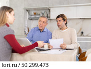 Two men listen attentively to saleswoman talking about the advantages of taking out microloan from credit institution. Стоковое фото, фотограф Яков Филимонов / Фотобанк Лори