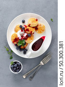 Baked cottage cheese pancakes, syrniki with yogurt, blueberry sauce and fresh berries. Стоковое фото, агентство Ingram Publishing / Фотобанк Лори