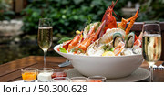 Panoramic web banner Bowl of groumet fresh seafood on ice with savory sauce serve with white wine glass on vintage wooden table. Restaurant gastronomy food and drink consumerism concept. Стоковое фото, агентство Ingram Publishing / Фотобанк Лори