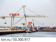 Big Cargo Containers Boat with Goods cargo Stack at the Pier docks port waiting for international sea freight transportation in Rotterdam Port of Netherlands. Стоковое фото, агентство Ingram Publishing / Фотобанк Лори