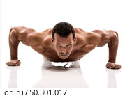 Muscle man making pushups in studio, isolated over a white background. Стоковое фото, агентство Ingram Publishing / Фотобанк Лори