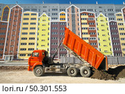 Building urban scene. Multistorey building apartment house and dump truck unload soil at day. . Стоковое фото, агентство Ingram Publishing / Фотобанк Лори