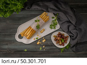Fresh baked homemade grissini bread sticks in white ceramic tray with olive oil and basil herbs over kitchen counter top. Стоковое фото, агентство Ingram Publishing / Фотобанк Лори
