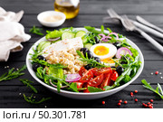 Greek style healthy breakfast bowl with oatmeal porridge and fresh vegetable salad of lettuce, arugula, olives, tomato, cucumber, feta cheese and boiled egg. Стоковое фото, агентство Ingram Publishing / Фотобанк Лори