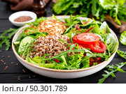 Lunch bowl with buckwheat porridge, fried chicken cutlets and fresh vegetable salad of arugula, lettuce, chard leaves, tomato, cucumber and flax seeds. Стоковое фото, агентство Ingram Publishing / Фотобанк Лори
