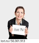 Business woman holding a card board with the text message "Hire me" and beging for a job. Стоковое фото, агентство Ingram Publishing / Фотобанк Лори