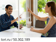 Asian customers touch on virtual screen to select menu on social distancing table for new normal lifestyle in restaurant after coronavirus covid-19 pandemic. New normal technology restaurant concept. Стоковое фото, агентство Ingram Publishing / Фотобанк Лори