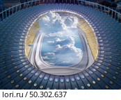 Aerial view construction of stadium with illuminator window and cloudy blue sky instead of football field in a night time. Travel and transportation concept.. View of stadium structure with porthole and clouds. Стоковое фото, агентство Ingram Publishing / Фотобанк Лори
