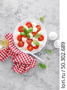 Caprese salad. Salad with mozzarella cheese fresh tomatoes, basil leaves and olive oil. Italian food. Стоковое фото, агентство Ingram Publishing / Фотобанк Лори