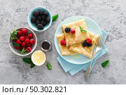 Thin crepes with fresh berries and lemon zest. Pancakes with raspberry and blackberry. Стоковое фото, агентство Ingram Publishing / Фотобанк Лори