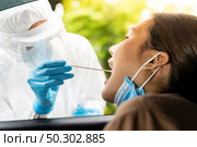 Portrait of asian woman drive thru coronavirus covid-19 test by medical staff with PPE suit by throat swab. New normal healthcare drive thru service and medical concept. Стоковое фото, агентство Ingram Publishing / Фотобанк Лори