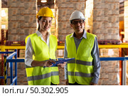 Portrait of asian warehouse manager and warehouse worker with clipboard to assign job with distribution warehouse in background. Reopening business warehouse technology and logistic concept. Стоковое фото, агентство Ingram Publishing / Фотобанк Лори