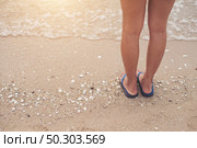 Young woman legs in flipflop sandals on sea beach. Стоковое фото, агентство Ingram Publishing / Фотобанк Лори