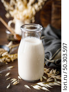 Vegan oat milk in glass bottle and ingredients for cooking. Healthy vegetarian non-dairy drink or beverage. Alternative milk. Стоковое фото, агентство Ingram Publishing / Фотобанк Лори