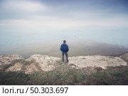 Man in fog in mountain looking to infinity. Conceptual scene. Стоковое фото, агентство Ingram Publishing / Фотобанк Лори
