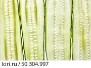 Creative natural background from cut slices of organic freshly picked cucumbers. Macro view. Vegetarian healthy food concept.. Vertical cut cucumber vegetable slices natural background. Стоковое фото, агентство Ingram Publishing / Фотобанк Лори