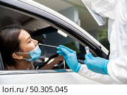 Portrait of asian woman drive thru coronavirus covid-19 test by medical staff with PPE suit by nose swab. New normal healthcare drive thru service and medical concept. Стоковое фото, агентство Ingram Publishing / Фотобанк Лори
