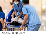 Medical team do CPR Cardiopulmonary resuscitation to seriously injured patient with oxygen mask while push gurney stretcher bed to Operating Room. Emergency health care and medical hospital concept. Стоковое фото, агентство Ingram Publishing / Фотобанк Лори
