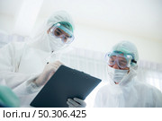 The doctor team take a medical care and treatment to contagious disease patient with the vaccine and drug by using face mask and PPE protection at the health care hospital. Стоковое фото, агентство Ingram Publishing / Фотобанк Лори